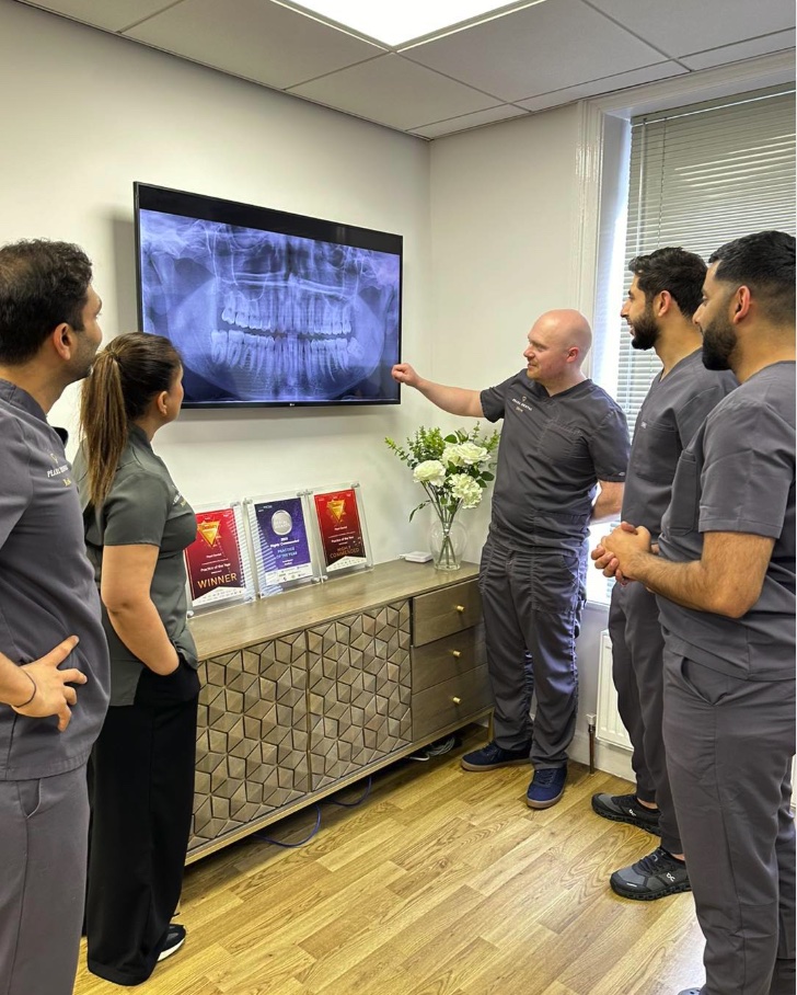 Pearl Dental clinicians reviewing a panoramic x-ray on a wall screen